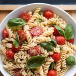 Elevate your meal with a pasta salad that exudes freshness and ease. The Gemelli Pasta Salad with Cherry Tomatoes and Basil is a perfect combination of textures and flavors, drizzled with a light, tangy dressing, offering a wholesome and delicious dining experience.